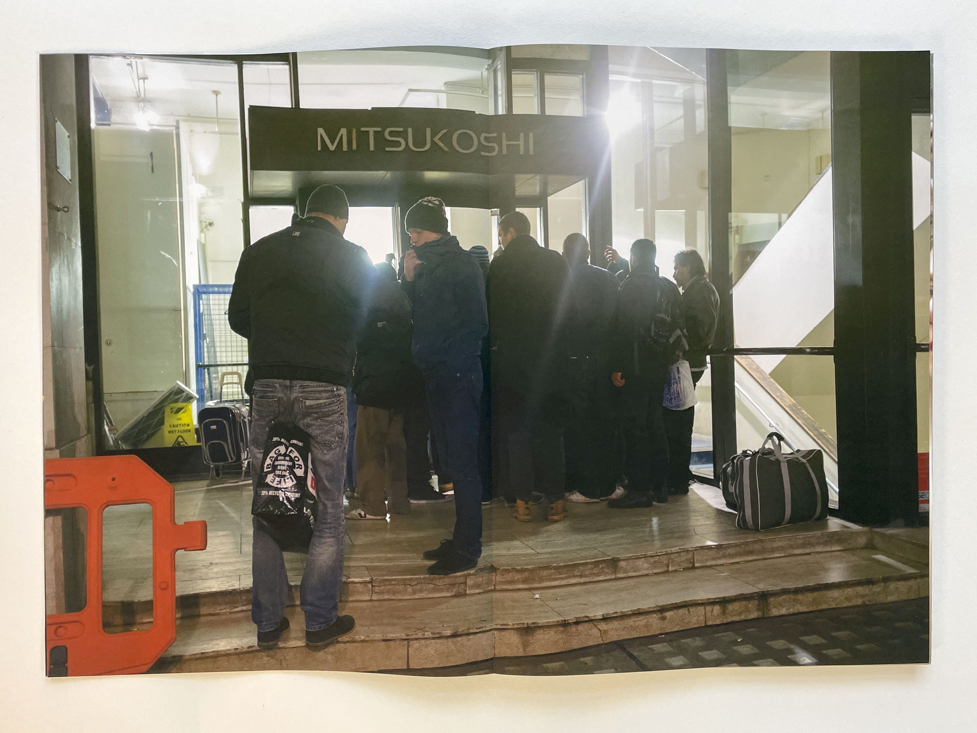 a group of men gather outside the entrance of a large building at night