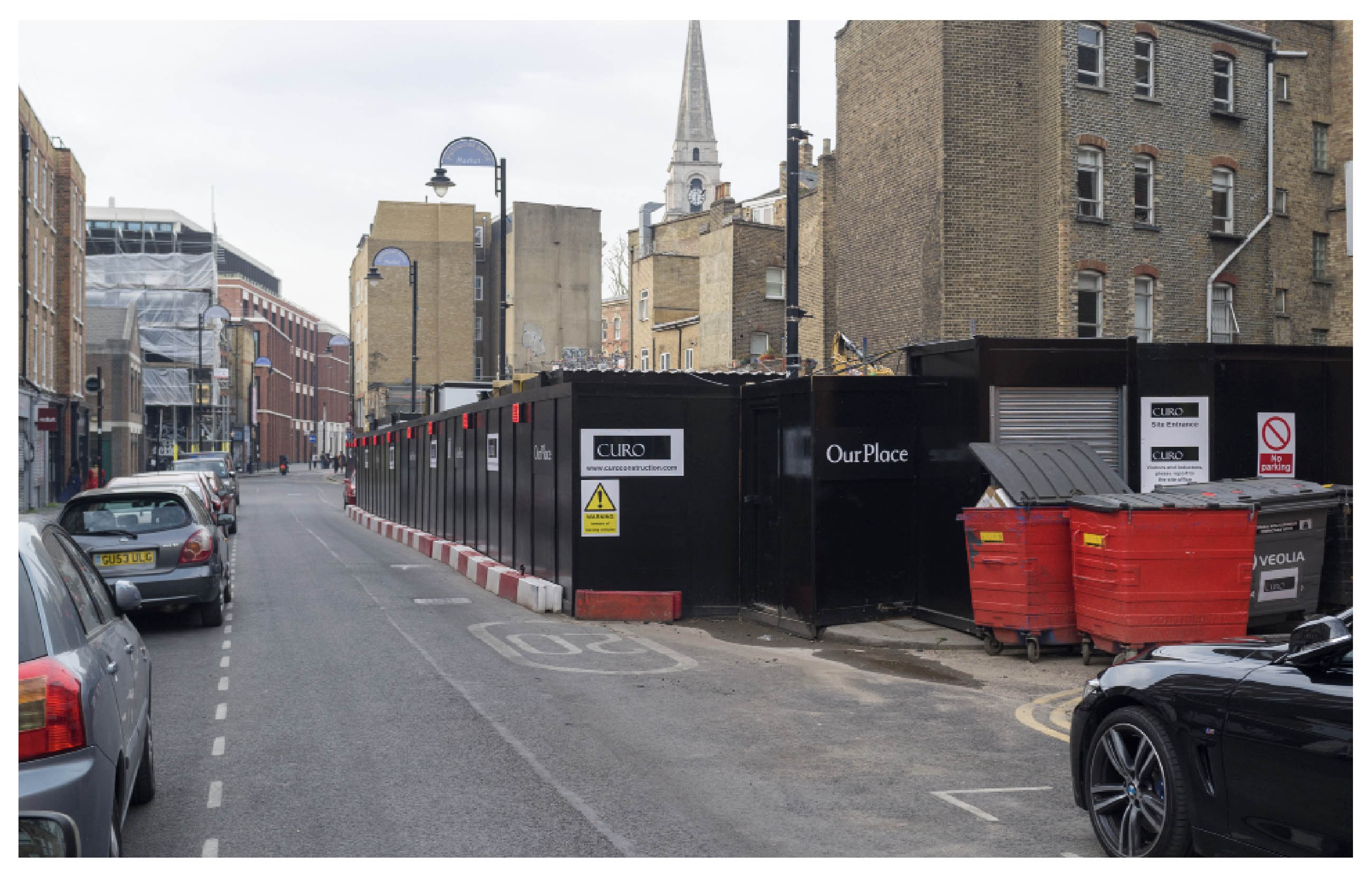 a street view with a hoarding on which the words Our Place are visible