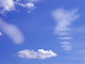 Hot, pale blue sky dappled with hazy clouds