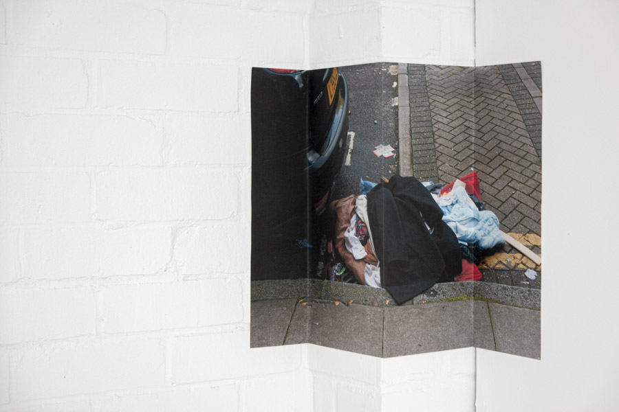 a view of the six large glossy photographic prints of the tops of skyscrapers strewn on the floor below the grid of images, at the centre of each print stands a Costa coffee cup