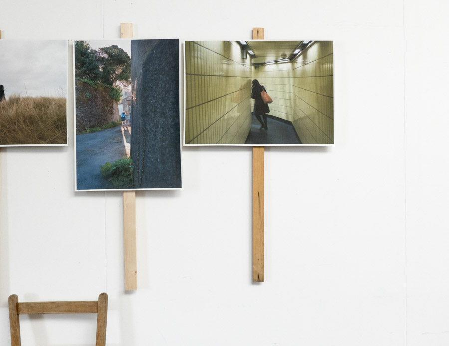 a view of the six large glossy photographic prints of the tops of skyscrapers strewn on the floor below the grid of images, at the centre of each print stands a Costa coffee cup